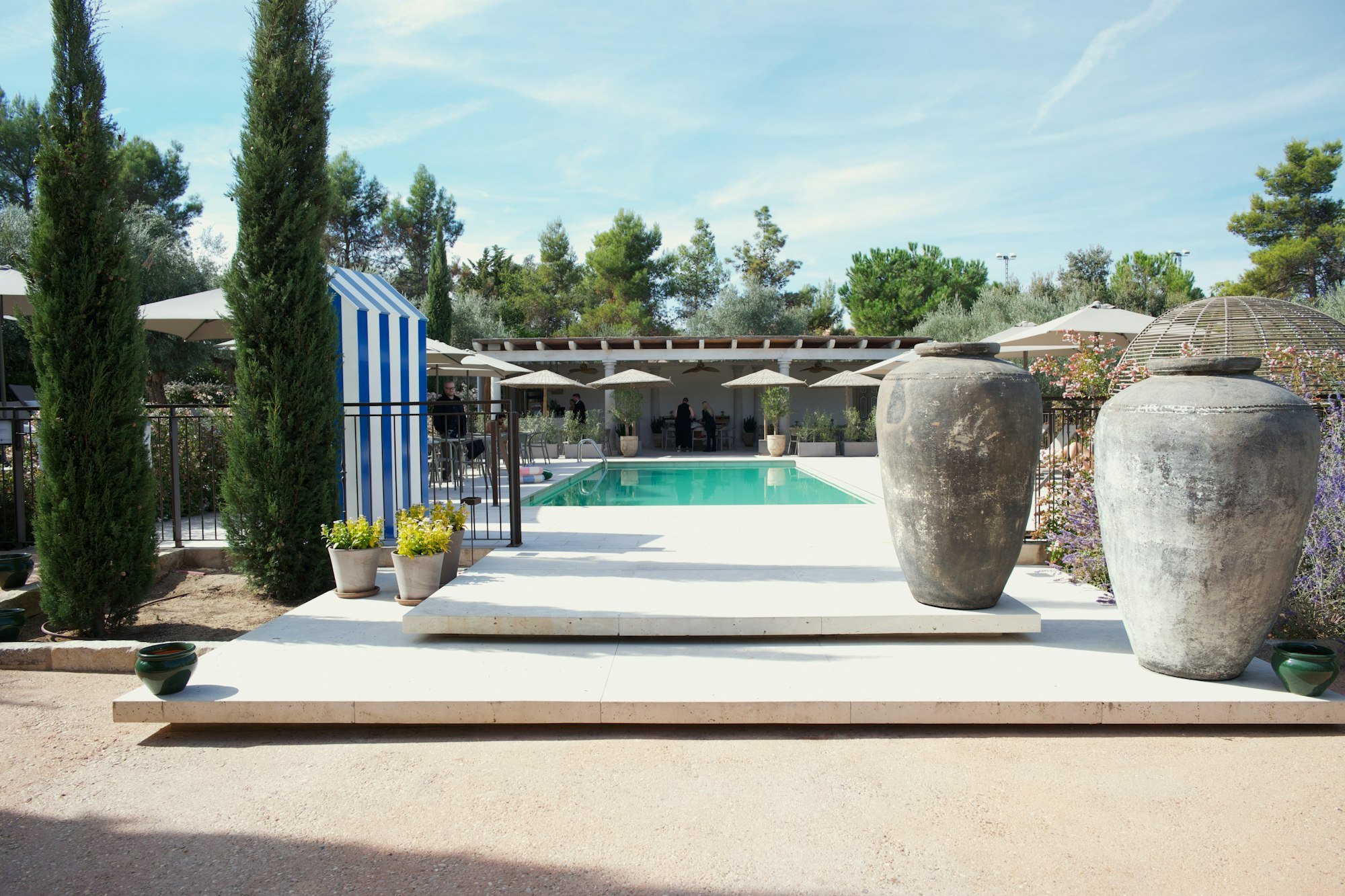 La piscine, ses grandes jarres et la haie de cyprès